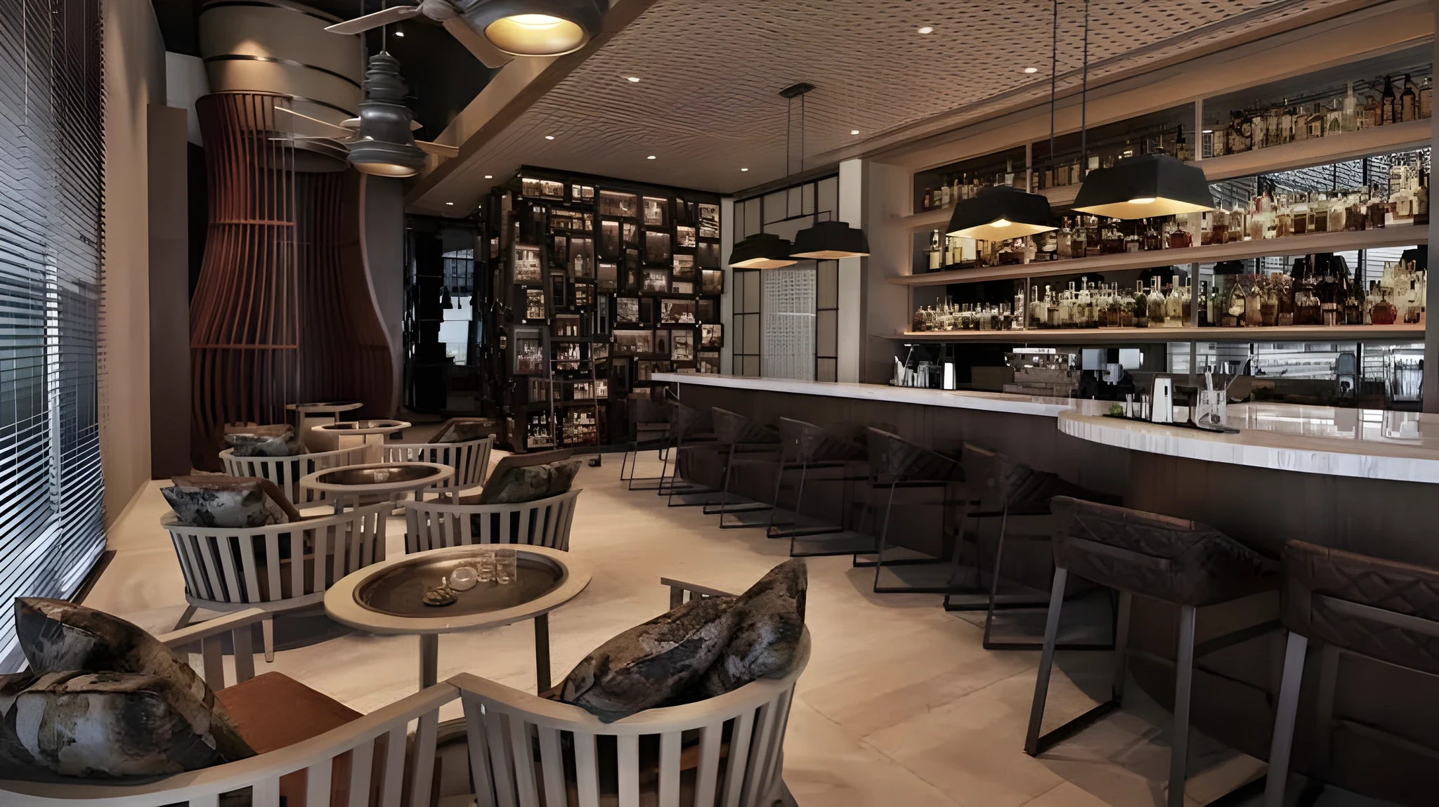 Interior of an upscale bar and lounge featuring a curved bar counter, illuminated shelves of bottles, brown leather chairs, small round tables with cushioned seats, pendant lights, and a paneled ceiling.